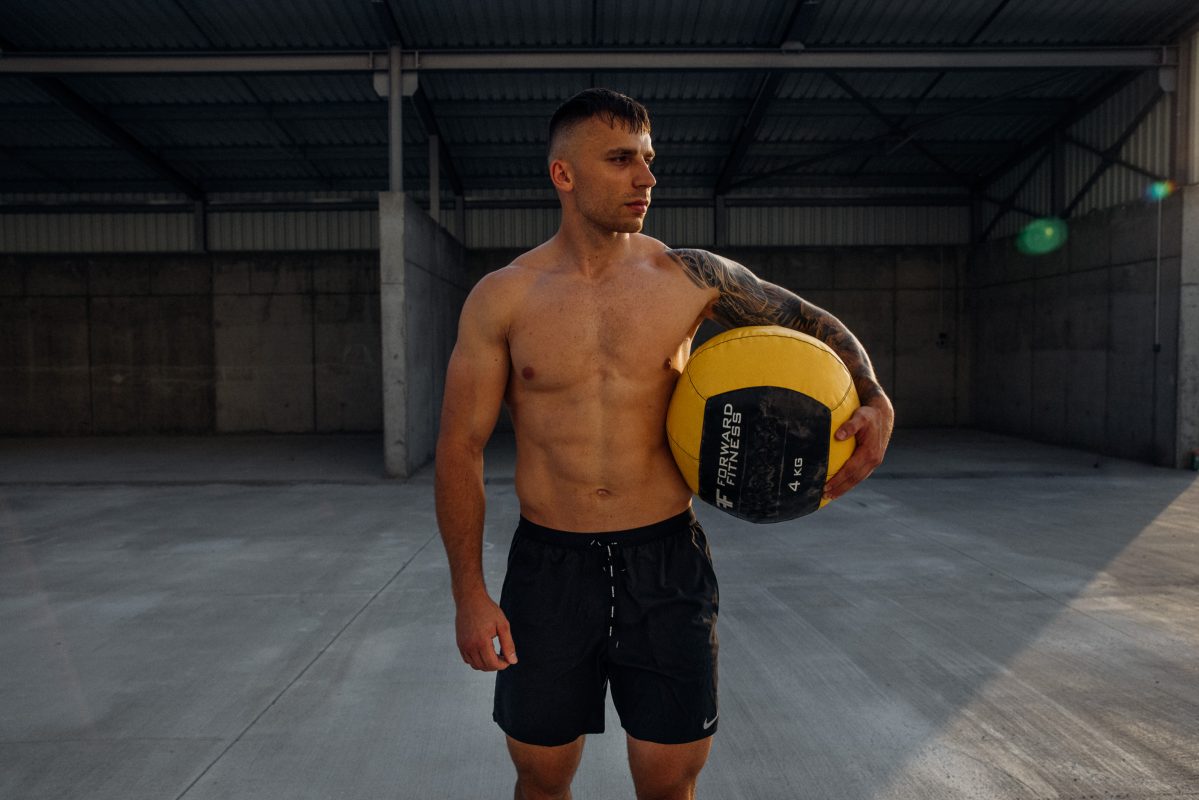 Vypracovaný muž s forward fitness wallbalom
