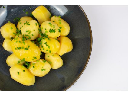 Vařené baby brambůrky bez slupky sypané pažitkou a přelité máslem 