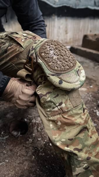 Detail taktické výstroje – kolenní chránič ALTA®️ nasazený na maskáčových kalhotách