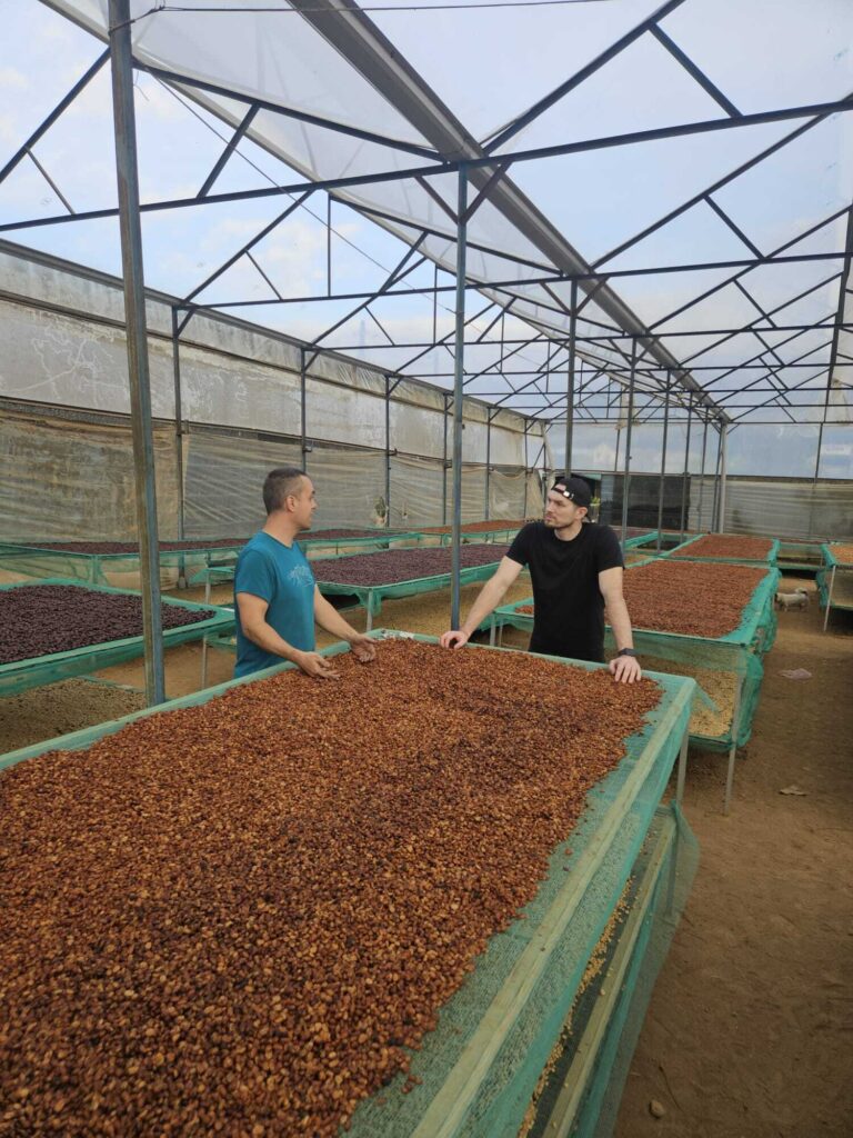 Simon Melišek (vpravo) v rozhovore s Mariánom Takáčom pri posteliach, na ktorých sa sušia očistené kávové zrná