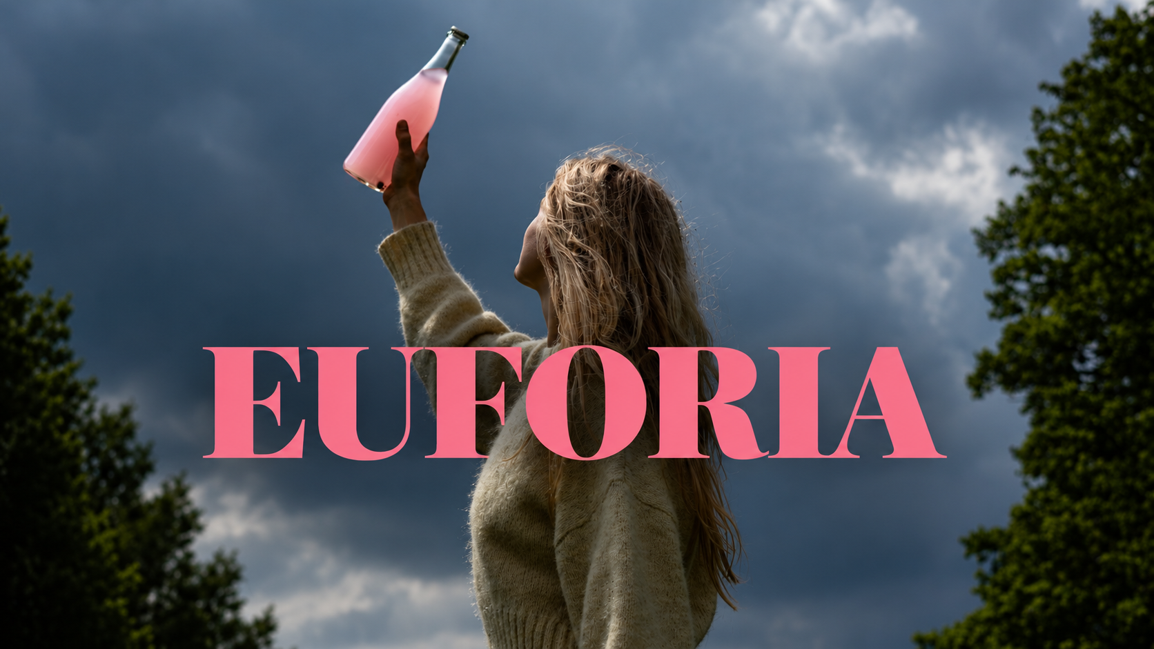 Žena drží láhev Euforie proti obloze