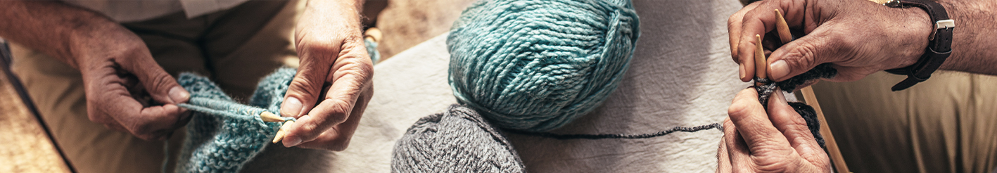 Senioři pletou – ruce s jehlicemi a klubky vlny