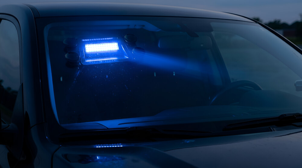 Modré výstražné LED stroboskopické světlo s přísavkami upevněné na čelním skle vozidla