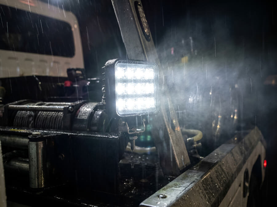 Atmosférický záběr na zapnuté odolné čtvercové pracovní LED světlo na vozidle v noci - Odolné čtvercové pracovní LED světlo 12W, IP68, 12V/24V