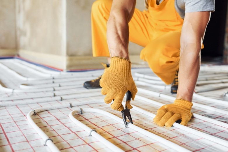 Profesionální technik montuje rozvody podlahového topení