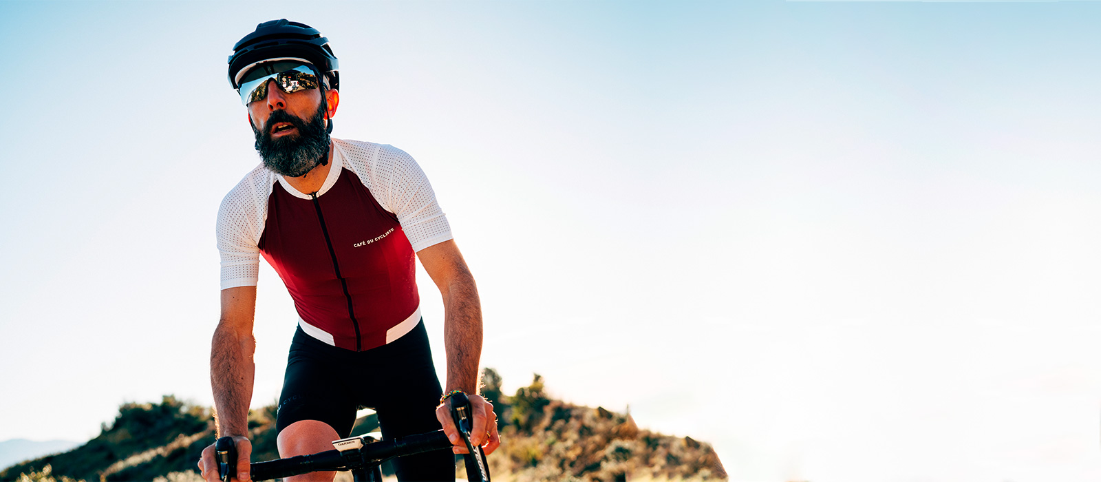 Cyklista v červeno-bílém dresu Café du Cycliste
