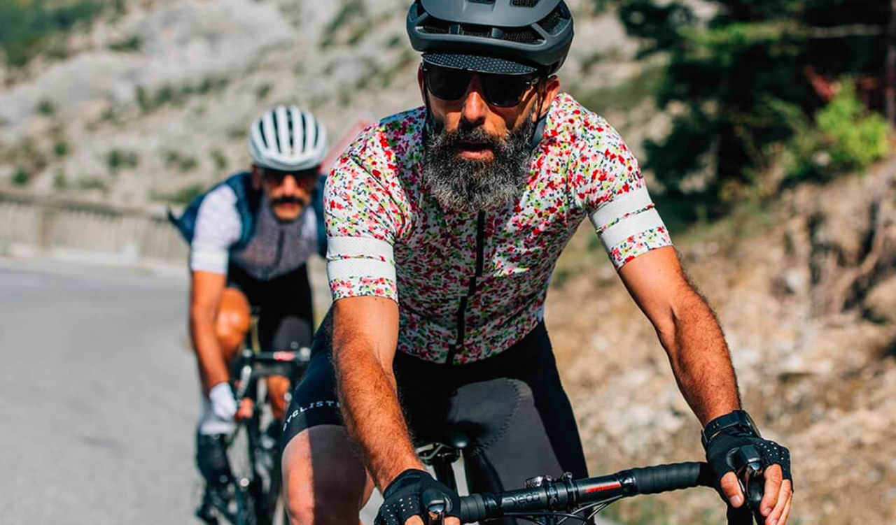Cyklista v květinovém dresu Café du Cycliste na silnici