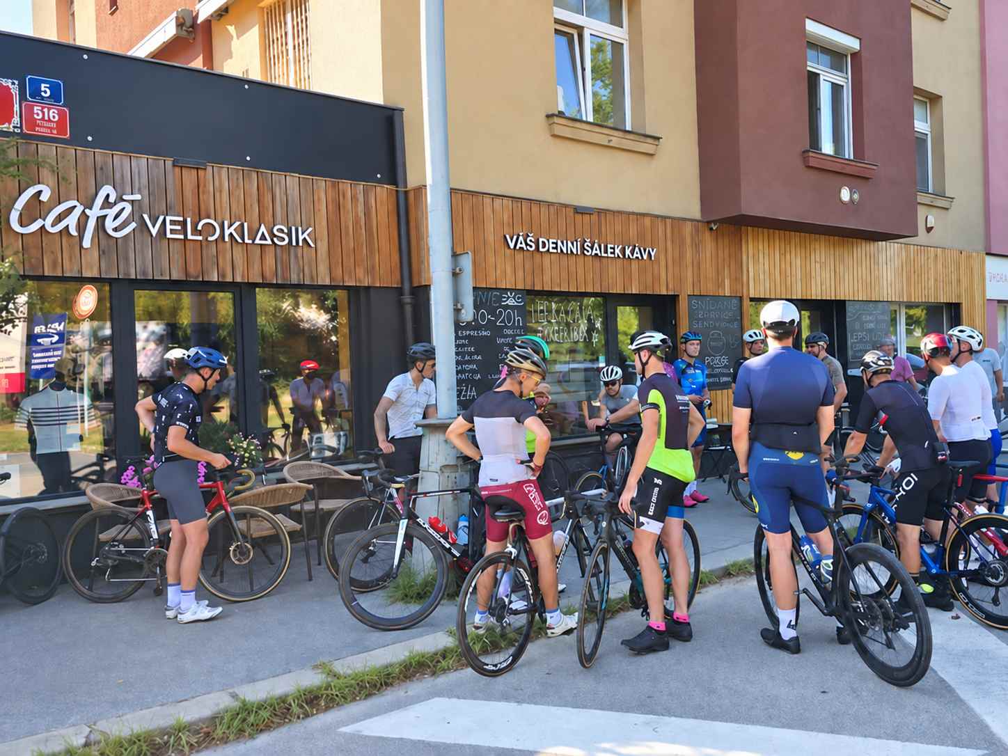 Cyklisté se scházejí před kavárnou a butikem Veloklasik v Braníku
