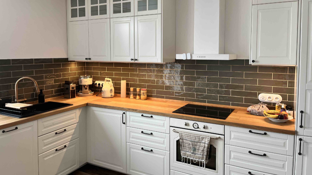 Bílá kuchyně se zelenými tlumenými obklady ve tvaru obdélníku – realizace.