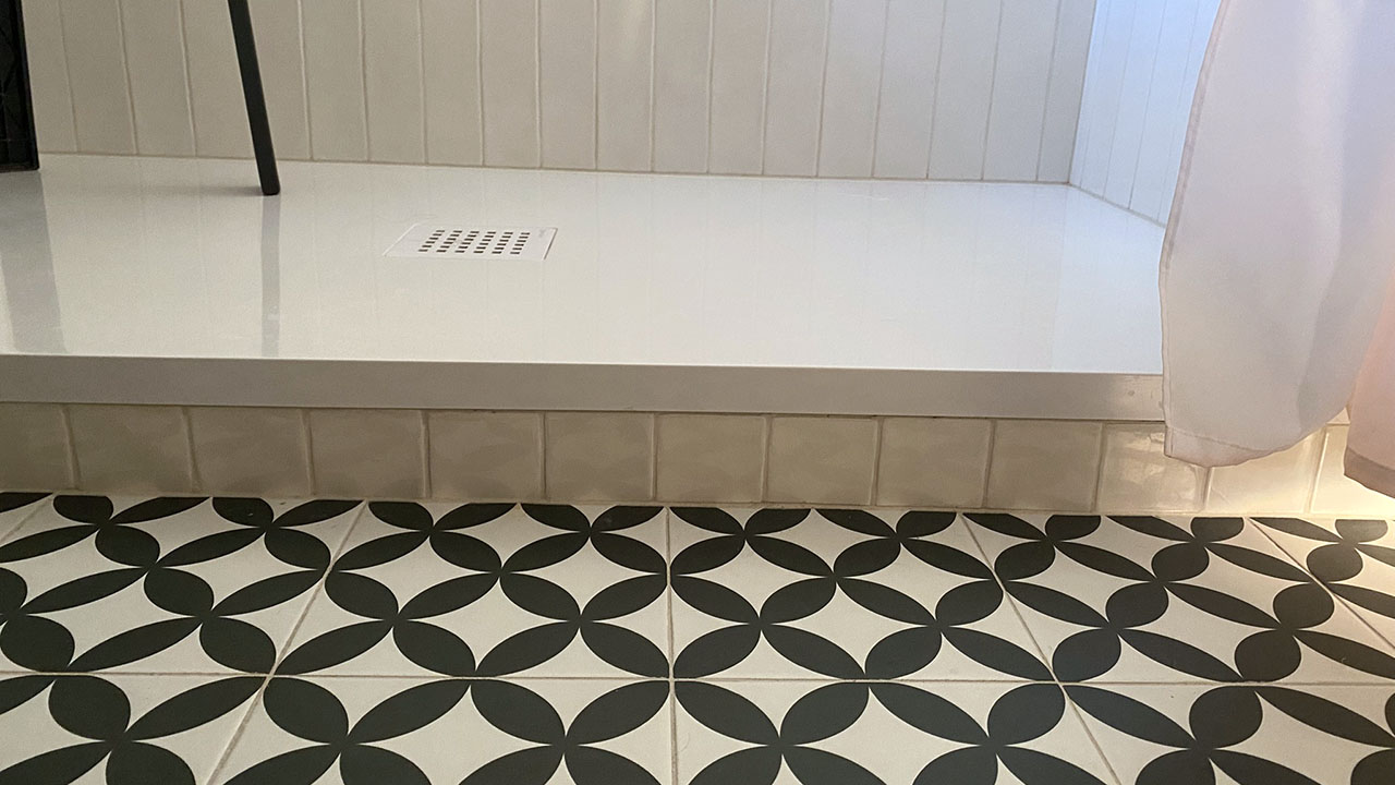 Koupelna s bílými obklady a černo-bílou dlažbou Fleur Noir