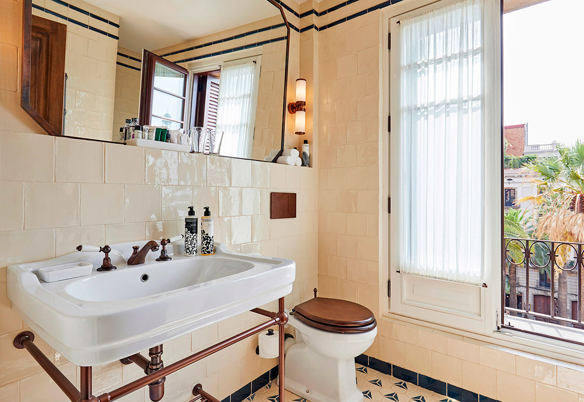 Retro koupelna s bílými obklady a černými listelami.