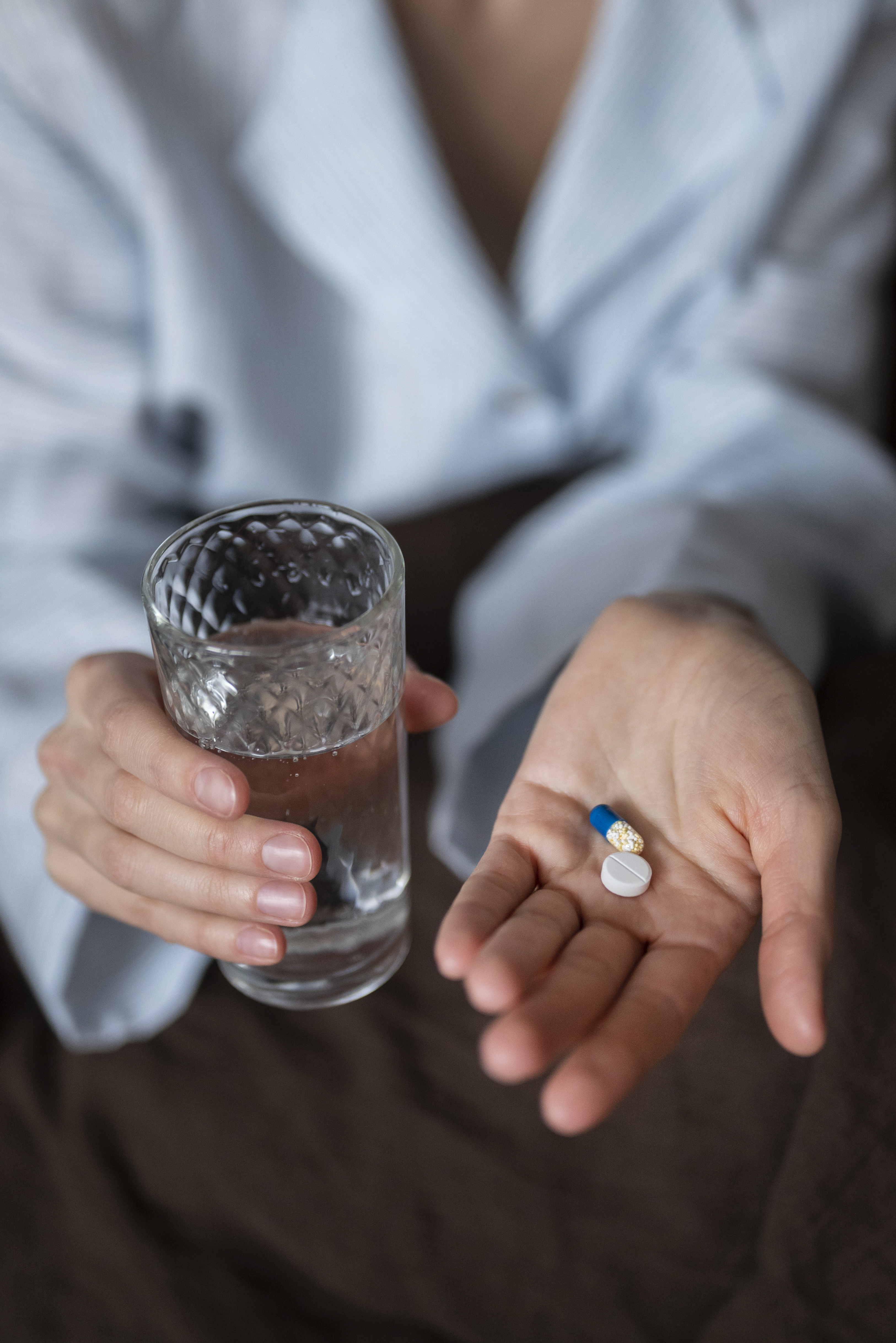 close-up-hands-holding-pills-water