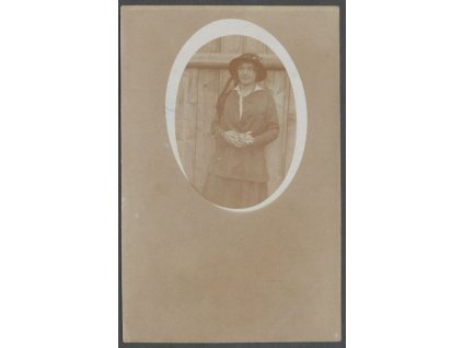 Žena s rukavicemi a kloboukem u plotu, ca 1916