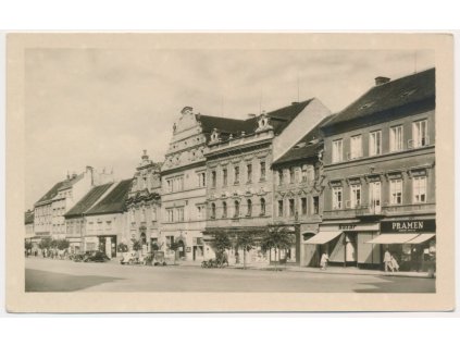 46 - Písek, oživená partie z náměstí s obchody a automobily, cca 1950