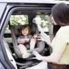 Autosedačka Joie i-Harbour™ E Signature v tmavošedej farbe ebony nainštalovaná v aute s dieťatkom vo výstupnej polohe natočená do dverí