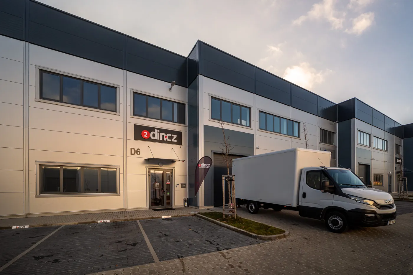 Hala D6 v Letňany Business Park – vchod do prodejny 2din.cz a parkoviště před ním