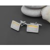 Manžetový knoflíček ve tvaru obdélníku v barvě stříbrné, který je doladěn s jemným žlutým tenkým proužkem