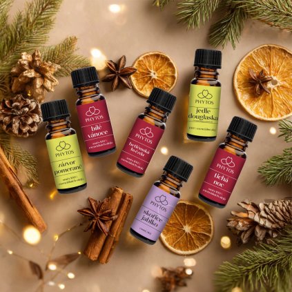 Sada šesti esenciálních olejů s vánočními vůněmi na zimním přírodním pozadí, skořice, citrusy a jehličí.