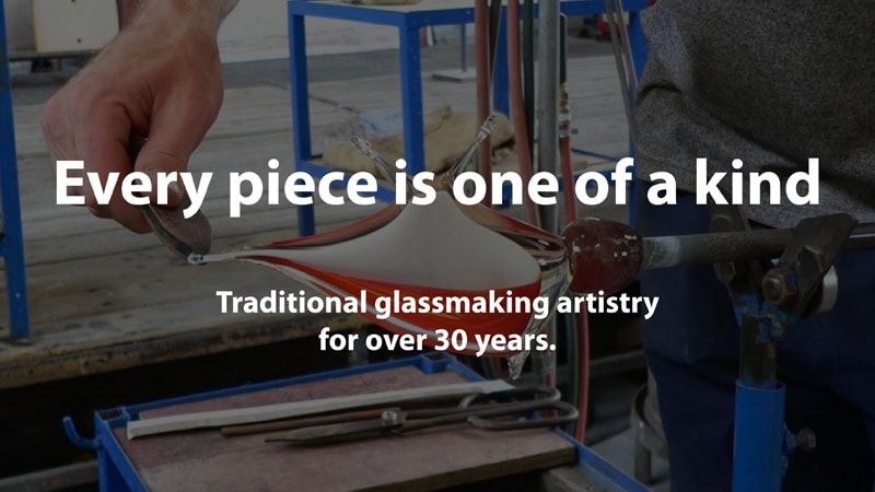 Traditional glassmaking process with glowing molten glass being shaped by hand.