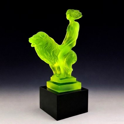 Art Deco nude lady on lion hood ornament made of yellow uranium glass on black glass base with UV glow