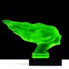Uranium glass Speed Girl hood ornament with black glass base showing strong UV glow under blacklight