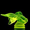 Side view of Art Deco fish figurine made of uranium glass under UV light