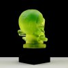 Back view of uranium glass skull hood ornament on black glass base with UV glow