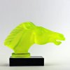 Art Deco horse head hood ornament made of uranium glass on black glass base with UV glow