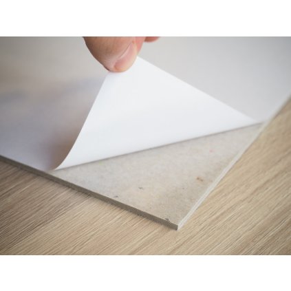 Self-adhesive board under a canvas