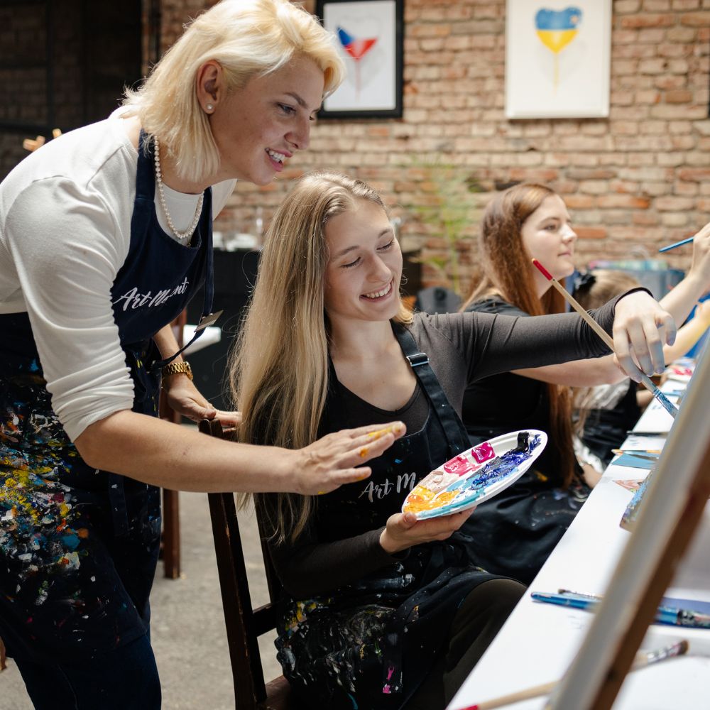 Instruktorka pomáhá účastnici kurzu malování ArtMoment