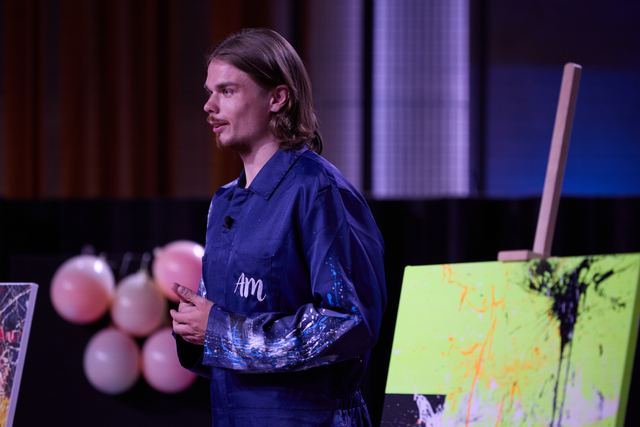 Egor zblízka u plátna s neonově zelenou abstraktní malbou