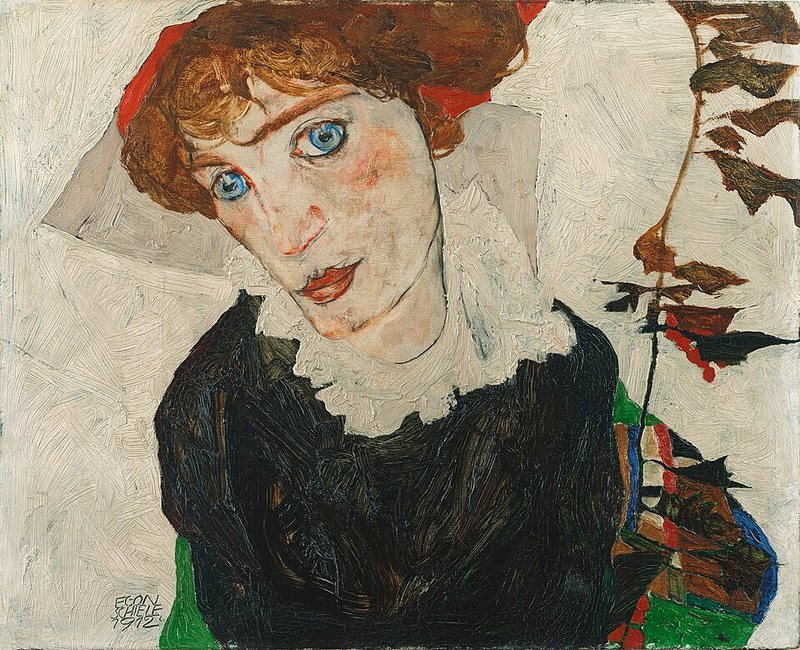 Portrét Wally Neuzilové od Egona Schieleho, 1912 – žena s rudými vlasy a velkýma modrýma očima v černých šatech s bílým límcem