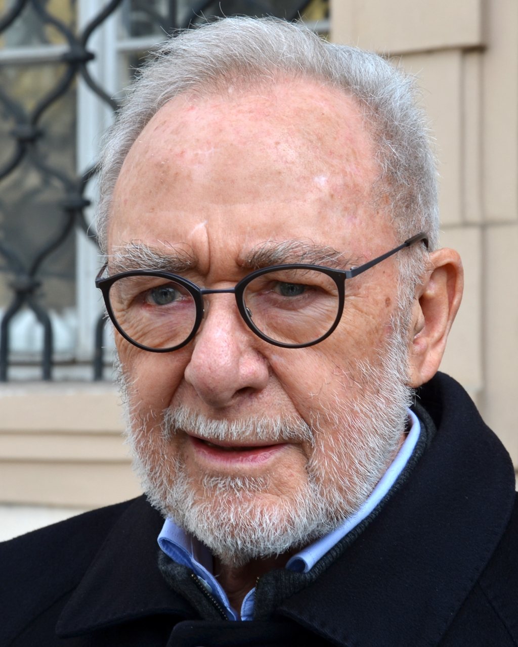 Gerhard Richter v Praze v roce 2017 – starší muž s šedivými vlasy a vousy, v kulatých brýlích a tmavém kabátě