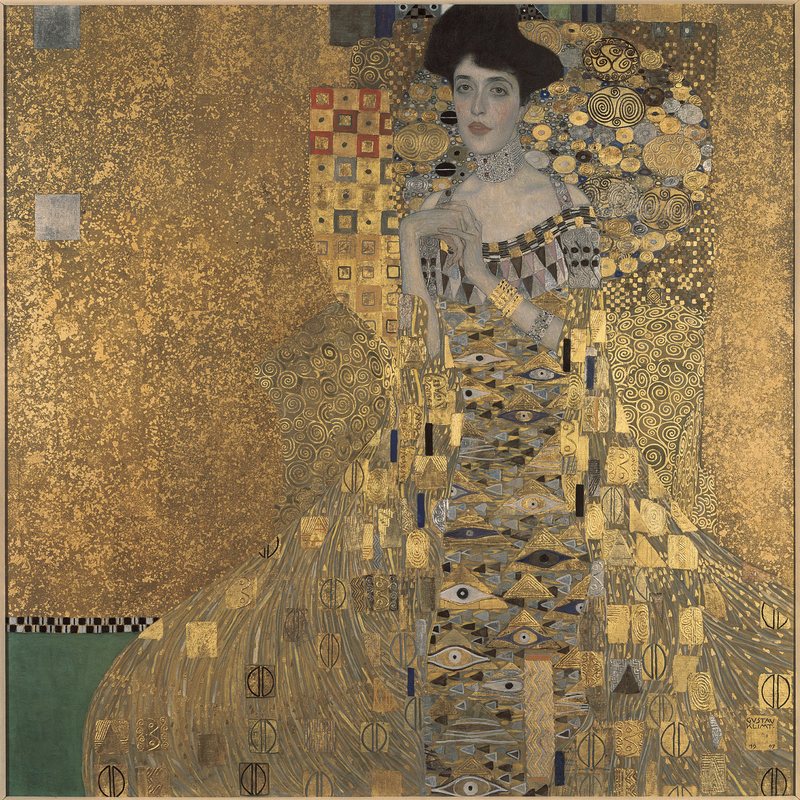 Portrét Adele Bloch-Bauer I od Gustava Klimta, 1907 – žena s tmavými vlasy a sepjatýma rukama obklopená zlatými ornamenty