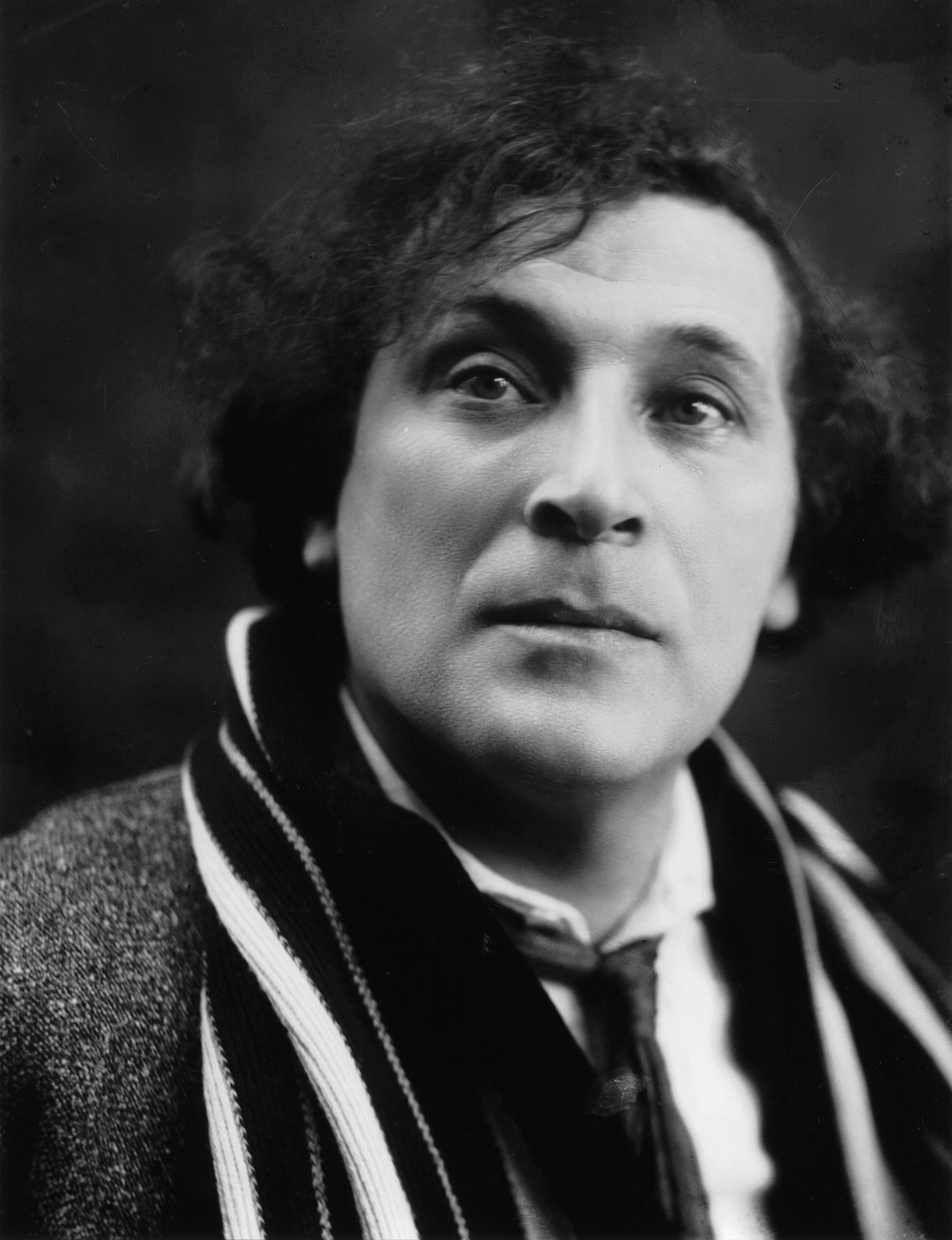 Marc Chagall ve 20. letech 20. století – černobílý portrét muže s rozcuchanými vlasy a pruhovanou šálou
