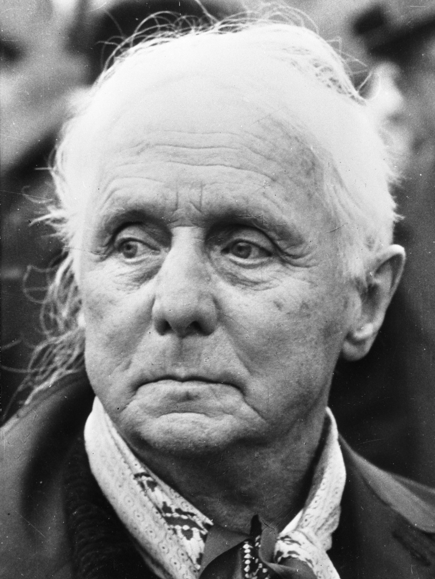 Max Ernst ve vyšším věku – černobílá fotografie muže s bílými vlasy a vzorovaným šátkem kolem krku
