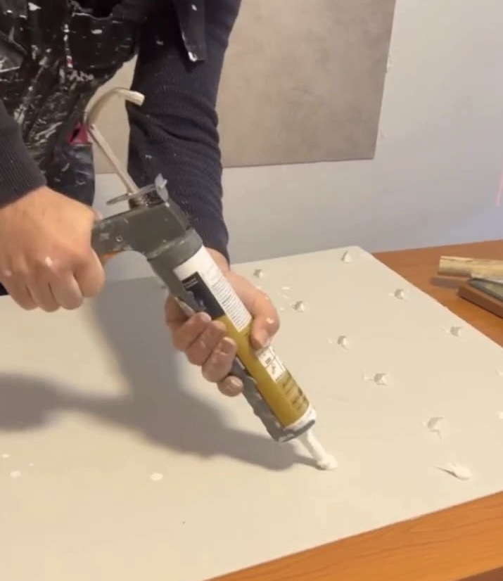 Auftragen von Kleber auf PVC Panel vor der Montage Detailansicht