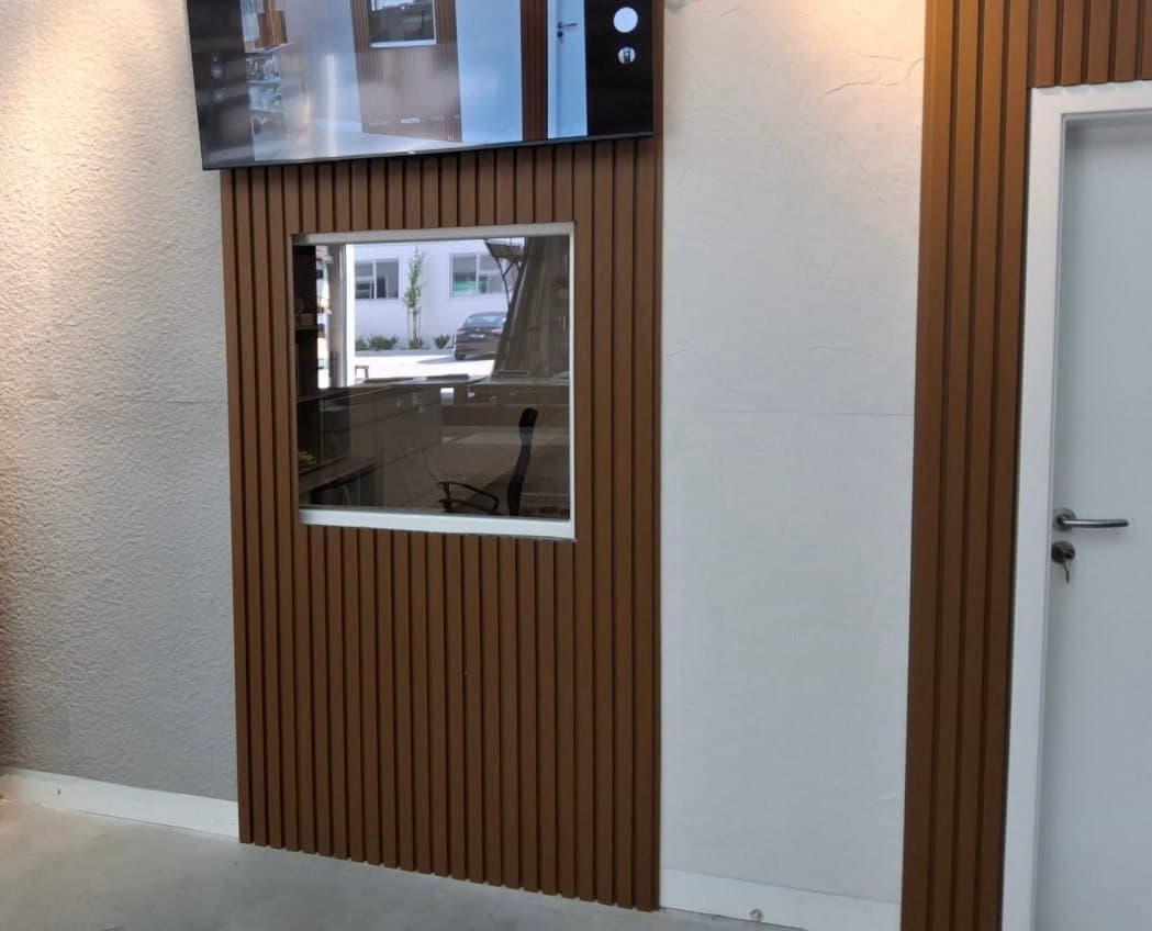 Kombinácia WPC lamiel a flexibilného kameňa v modernom interiéri s prírodným dizajnom steny a elegantným dreveným vzhľadom.