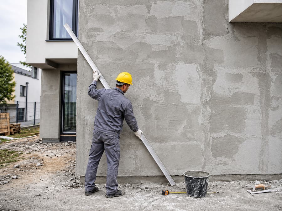 Kontrola rovinnosti podkladu pred montážou flexibilného kamenného obkladu.