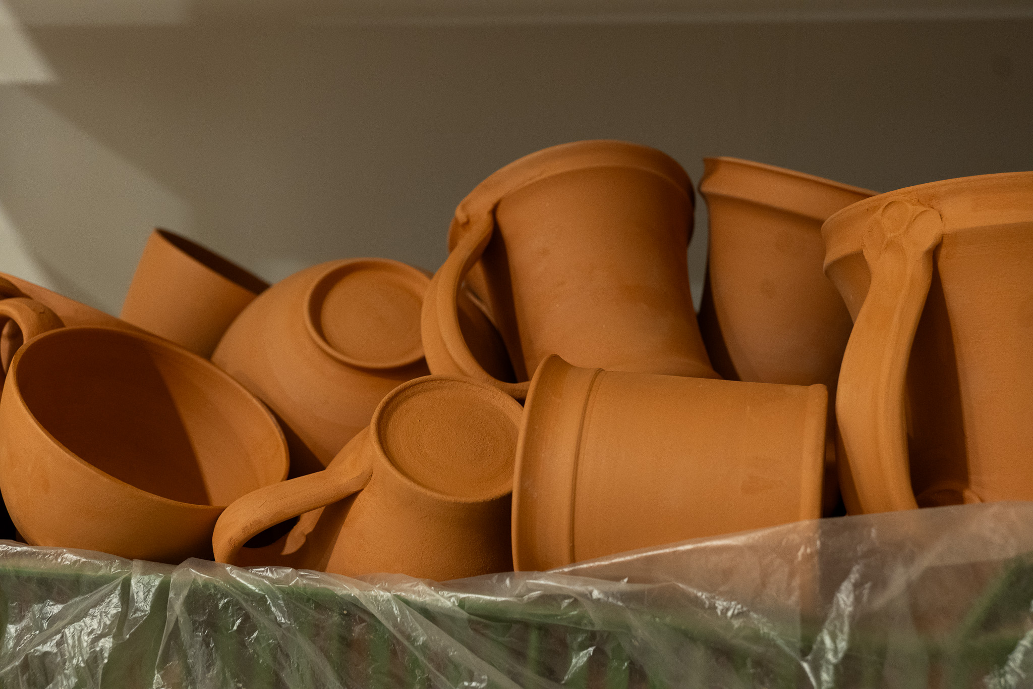 ručně dělané keramické hrnky a misky neglazované v keramickém ateliéru v Praze