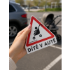 dítě v autě trojúhelník v ruce na parkovišti
