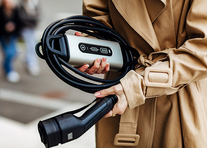 eMove_Mode2_width_urban_lady-holding-charger-and-plug_3939_700x500