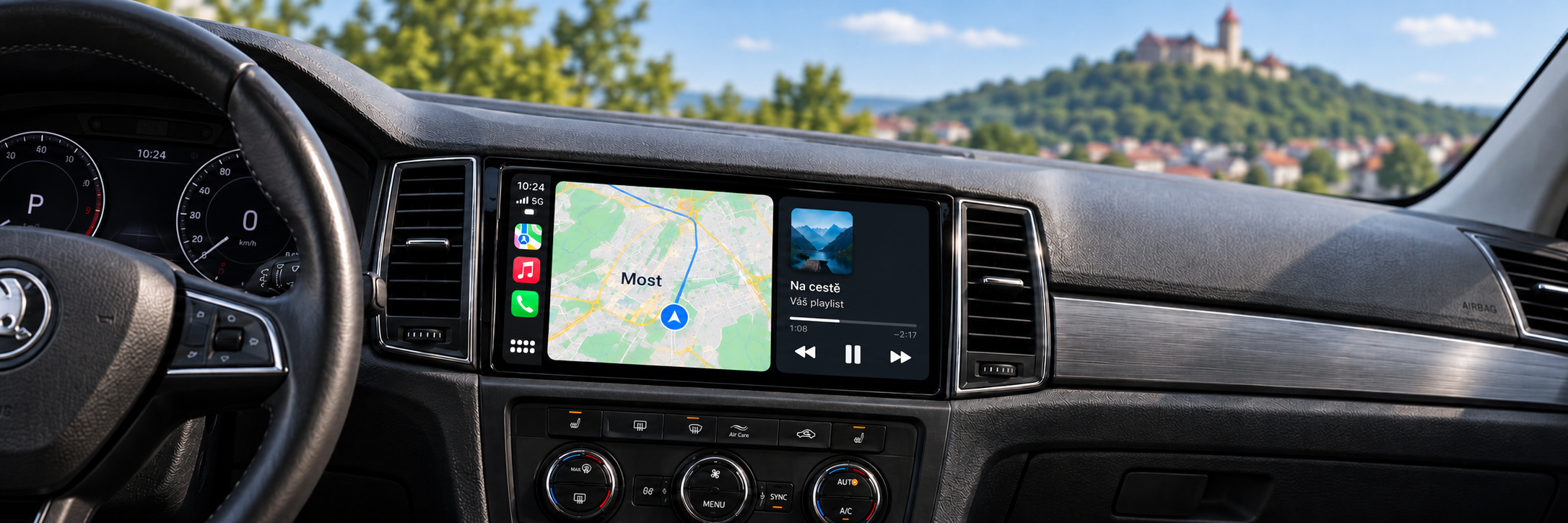 CarPlay s navigací Most a rozmazaným hradem Hněvín v pozadí – ilustrační zobrazení
