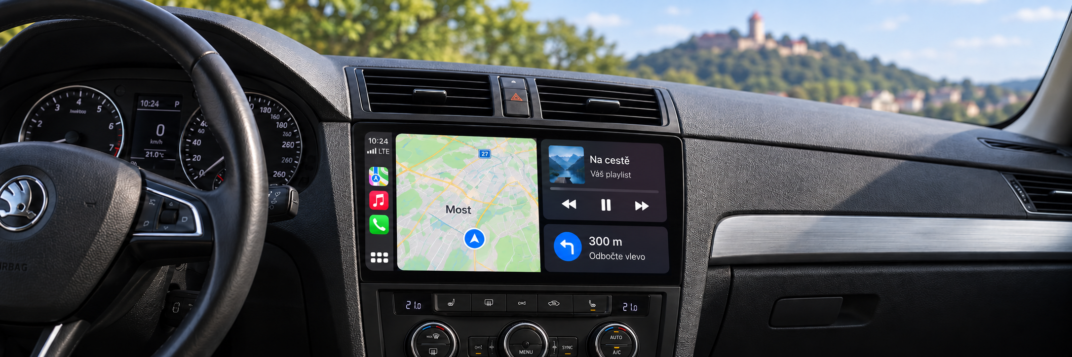 CarPlay s navigací Most a rozmazaným hradem Hněvín v pozadí – ilustrační zobrazení