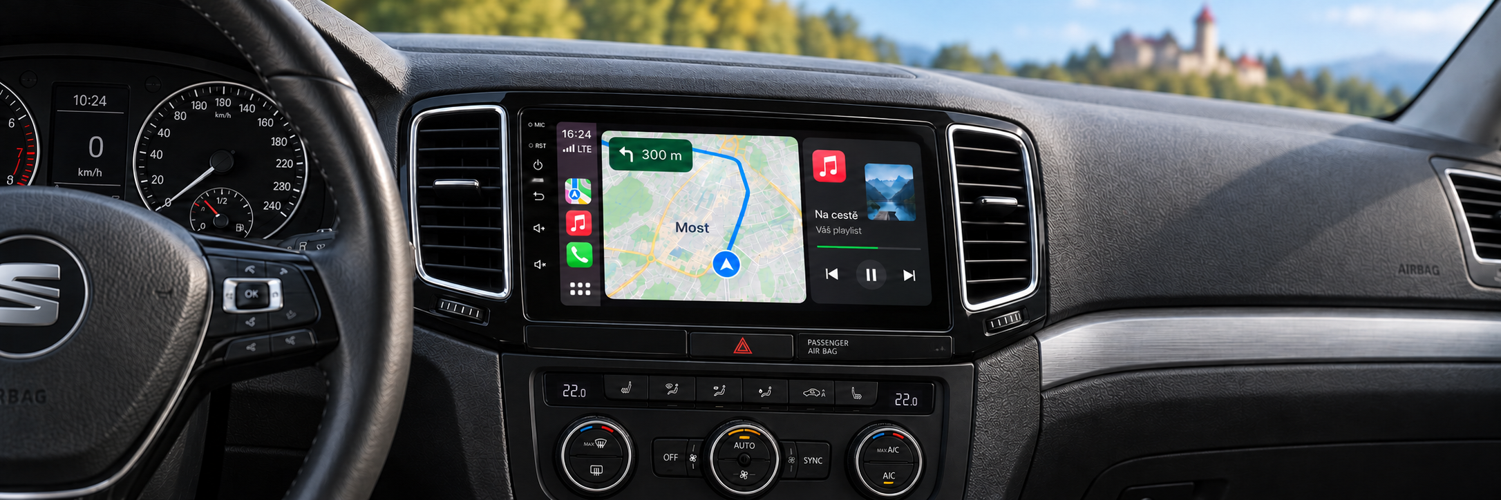 CarPlay s navigací Most v interiéru Seat Alhambra 2 a rozmazaným Hněvínem v pozadí