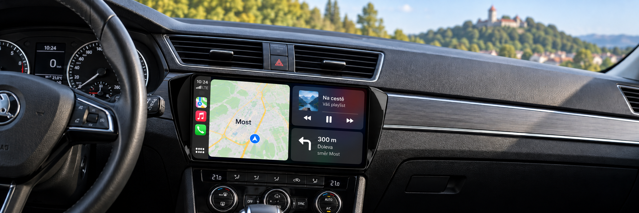 CarPlay s navigací Most a rozmazaným hradem Hněvín v pozadí – ilustrační zobrazení