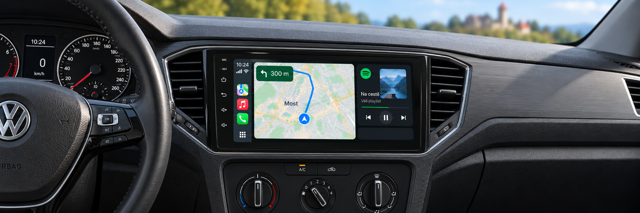 CarPlay s navigací Most v interiéru Volkswagen T-Roc / T-Cross a rozmazaným Hněvínem v pozadí