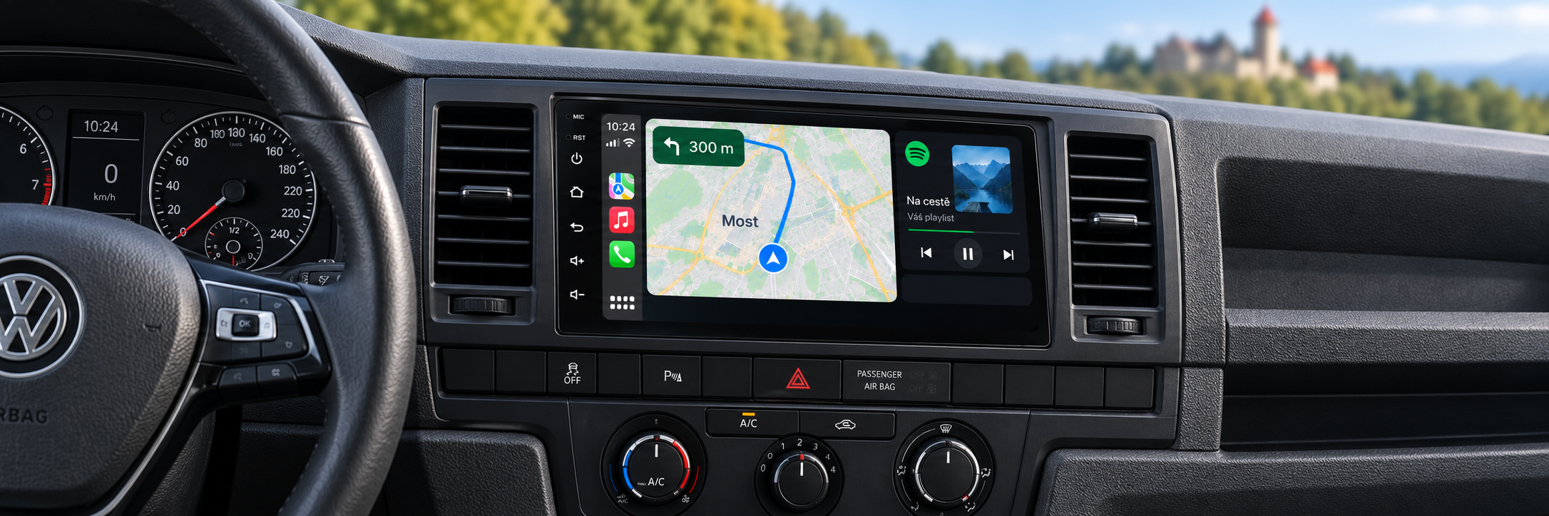 CarPlay s navigací Most v interiéru Volkswagen Transporter / Multivan T6 a rozmazaným Hněvínem v pozadí