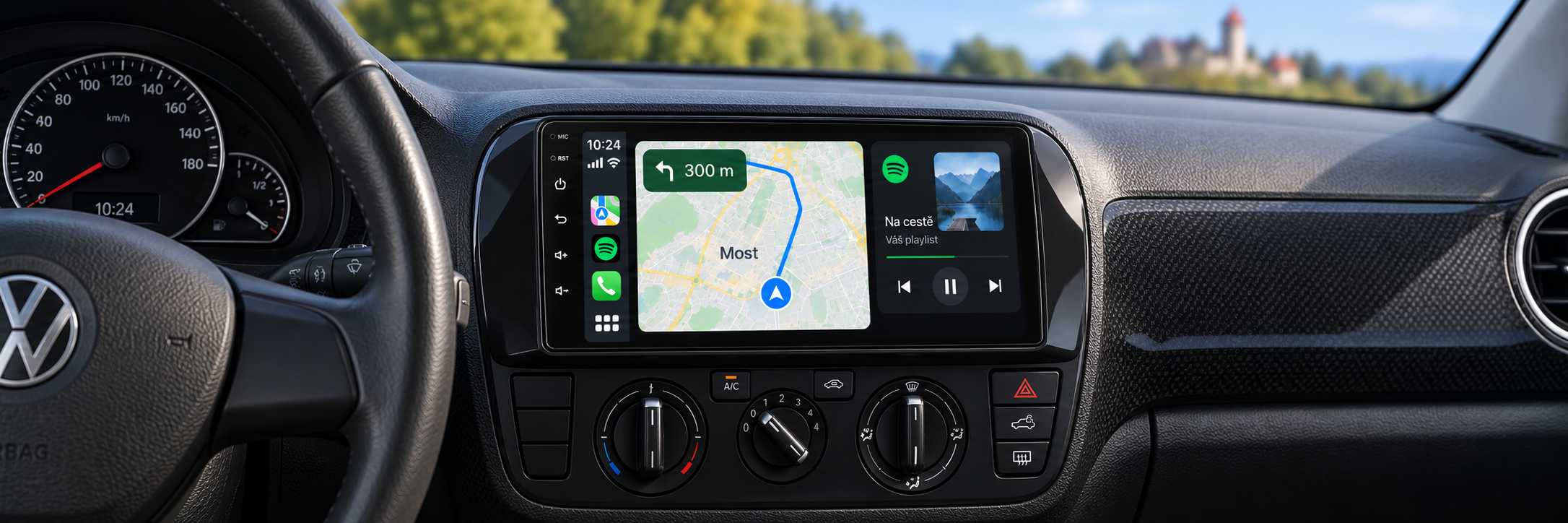 CarPlay s navigací Most v interiéru Volkswagen Up! a rozmazaným Hněvínem v pozadí