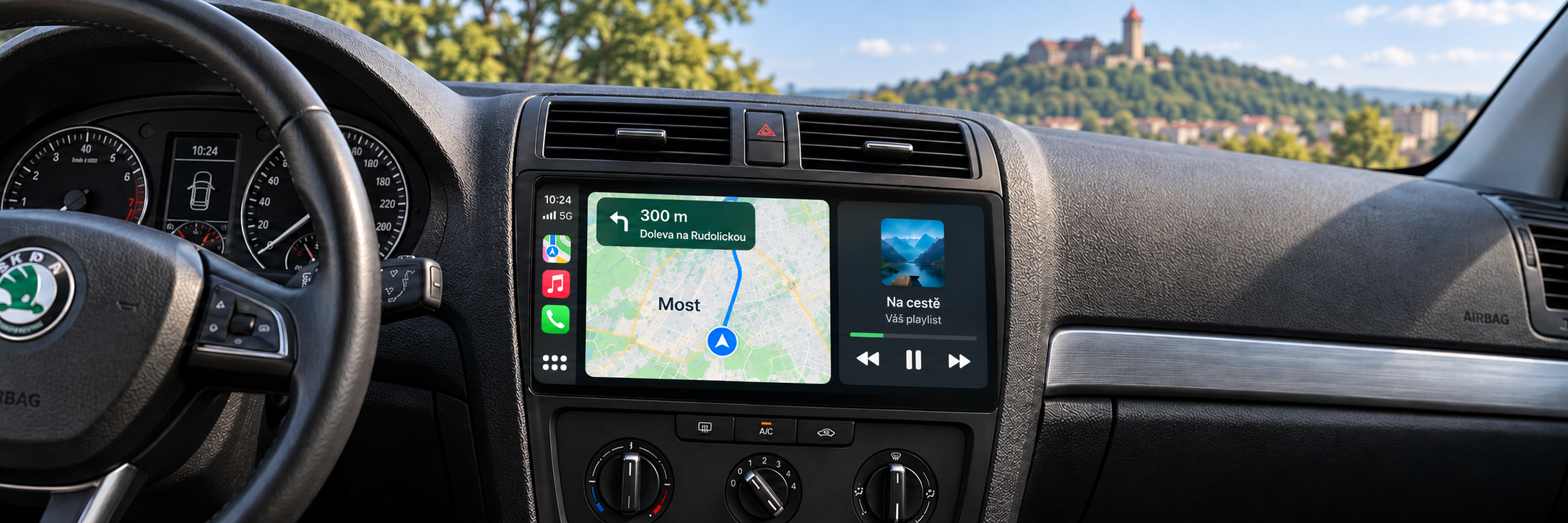 CarPlay s navigací Most a rozmazaným hradem Hněvín v pozadí – ilustrační zobrazení